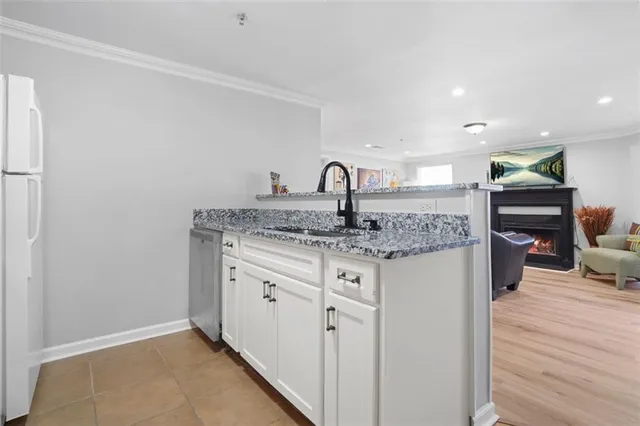 a kitchen with granite countertop a sink cabinets and wooden floor