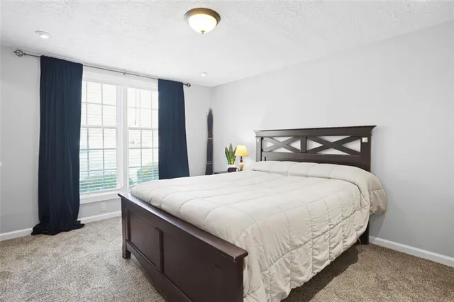 a bed sitting in a bedroom next to a window