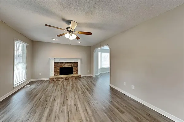 an empty room with windows and a fireplace