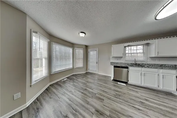 a large kitchen with granite countertop wooden floors a sink and a window
