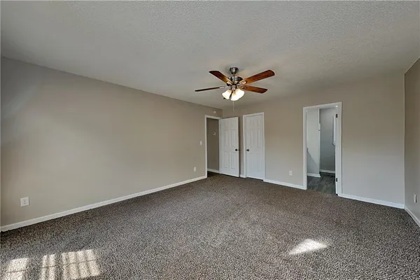 a view of an empty room with a chandelier fan