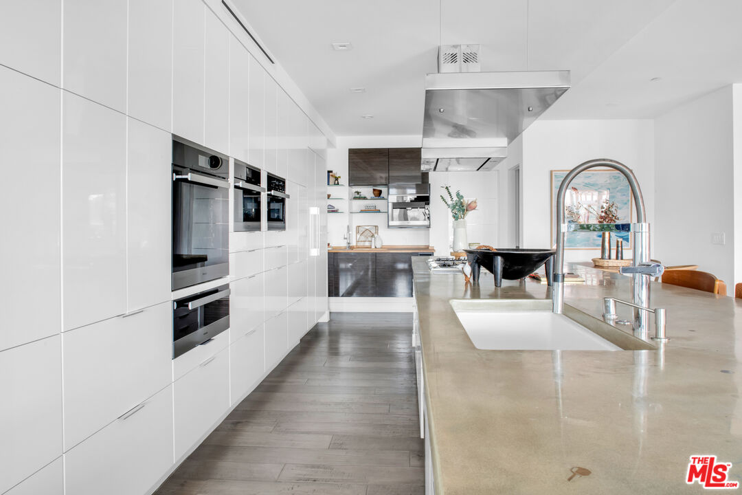2945 Angus Street Los Angeles, CA 90039 - Photo 15 of 52 a kitchen with stainless steel appliances kitchen island granite countertop a refrigerator a stove a microwave and a dining table with wooden floor