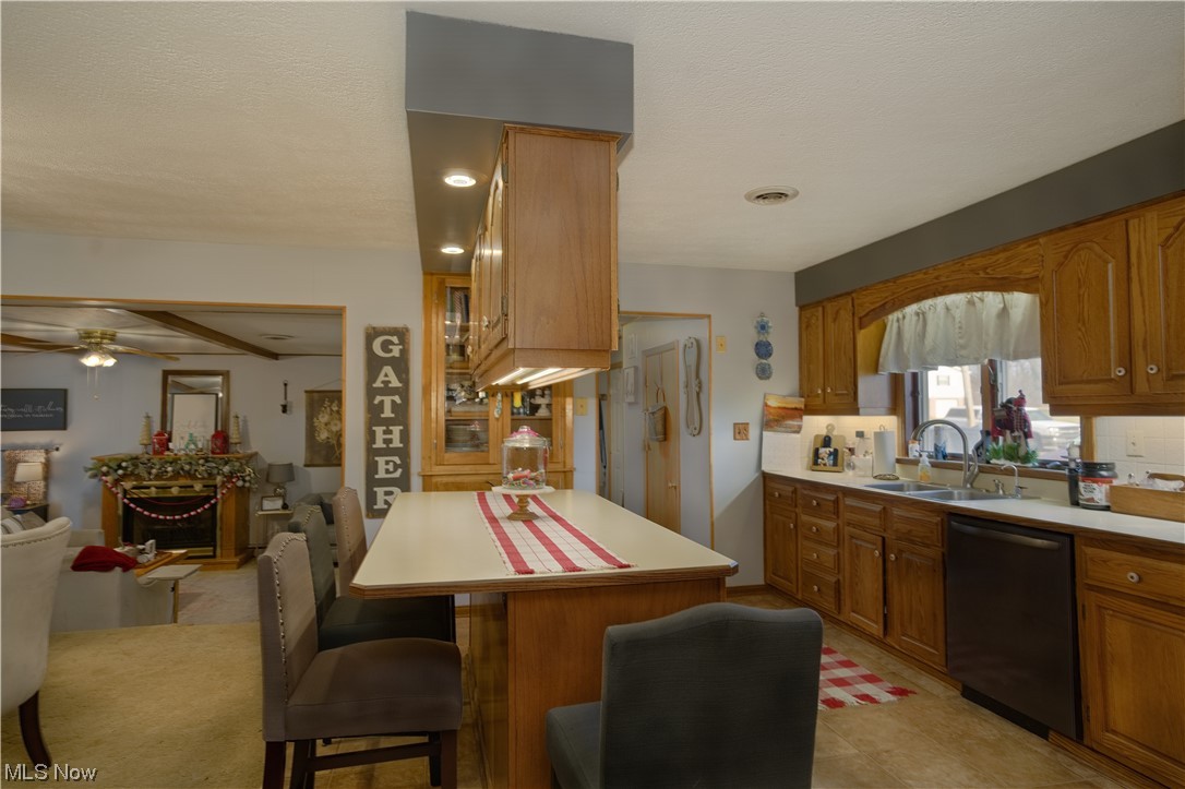 4061 Marks Rootstown, OH 44272 - Photo 9 of 25 Kitchen featuring a kitchen breakfast bar, light tile floors, dishwasher, ceiling fan, and sink