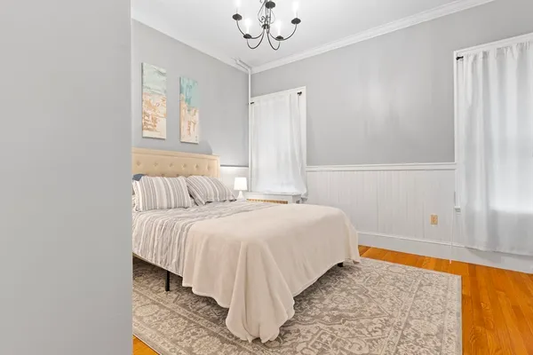 a bedroom with a bed and a chandelier