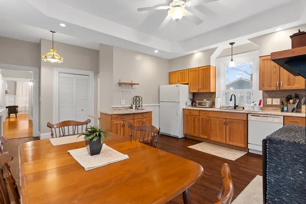 a kitchen with sink refrigerator dining table and chairs