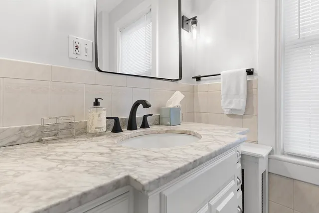 a view of a hallway with wooden floor and a bathroom