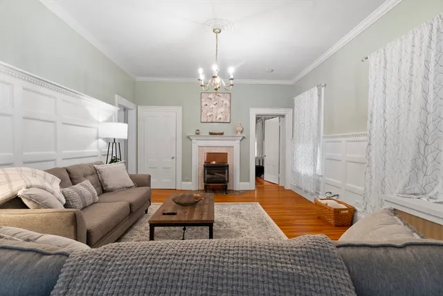 a living room with furniture a fireplace and a chandelier