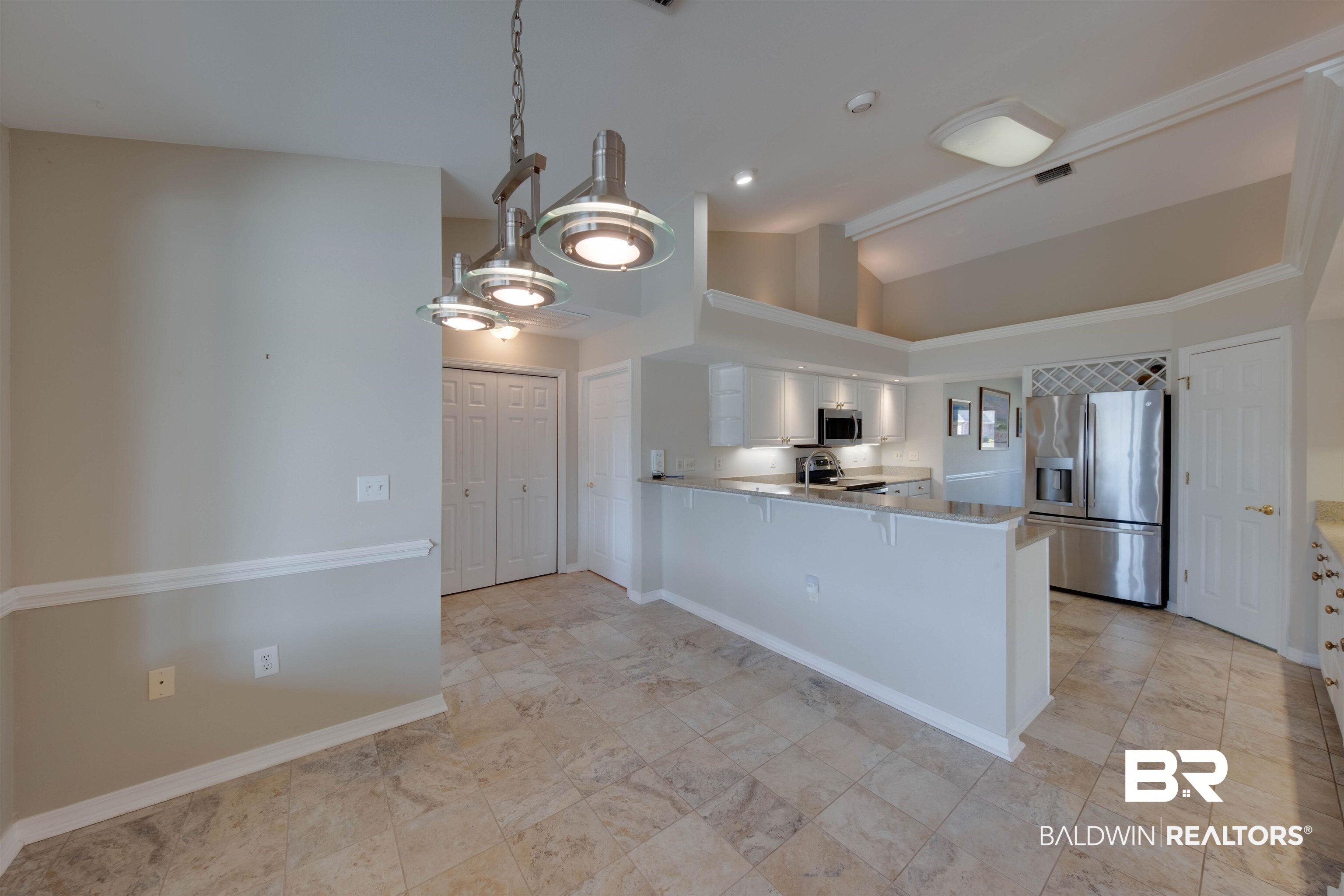 9462 Lakeview Drive Foley, AL 36535 - Photo 13 of 50 Kitchen with vaulted ceiling, appliances with stainless steel finishes, kitchen peninsula, and white cabinetry