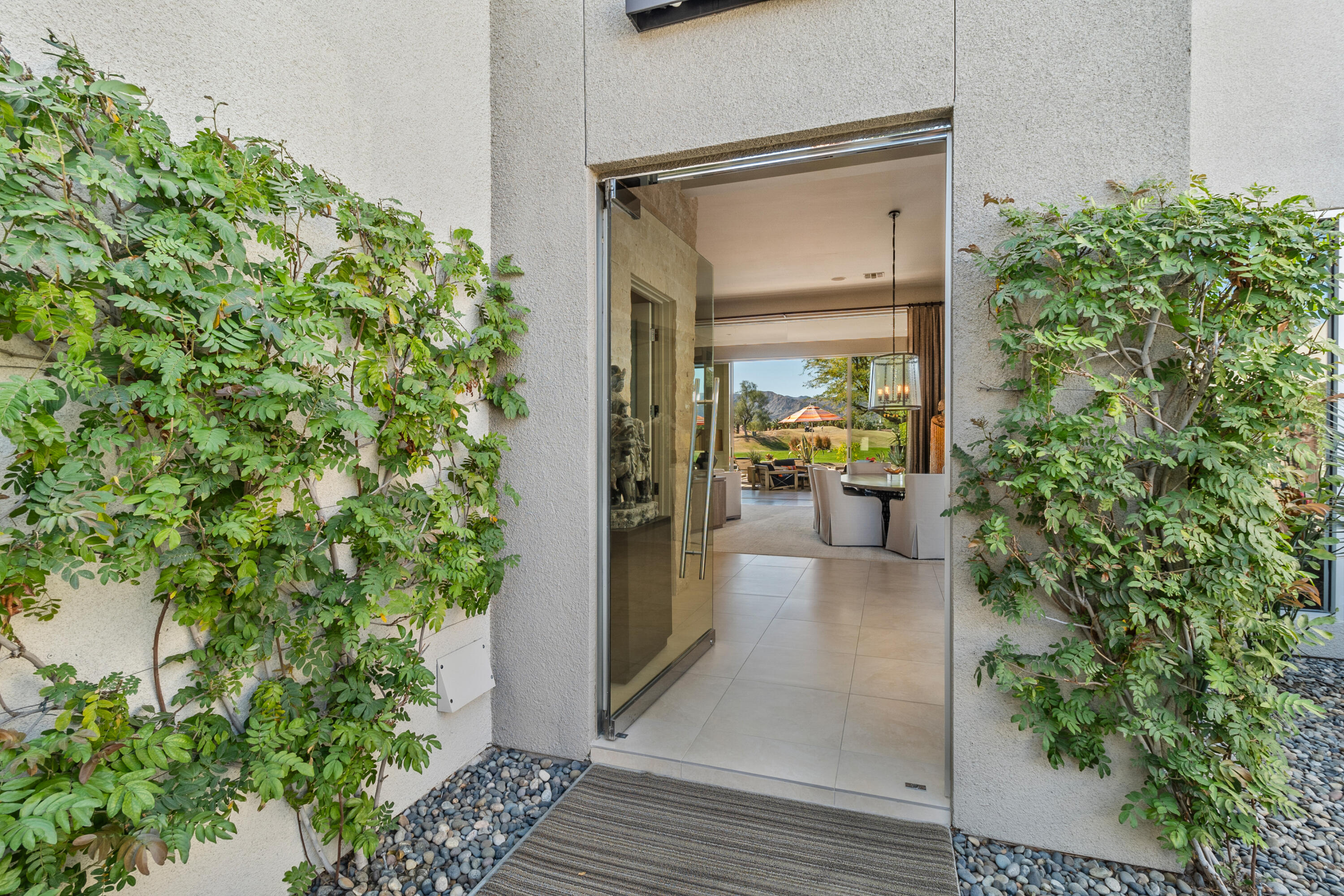 81 Royal St Georges Way Rancho Mirage, CA 92270 - Photo 18 of 59 a hallway with potted plants in front of door