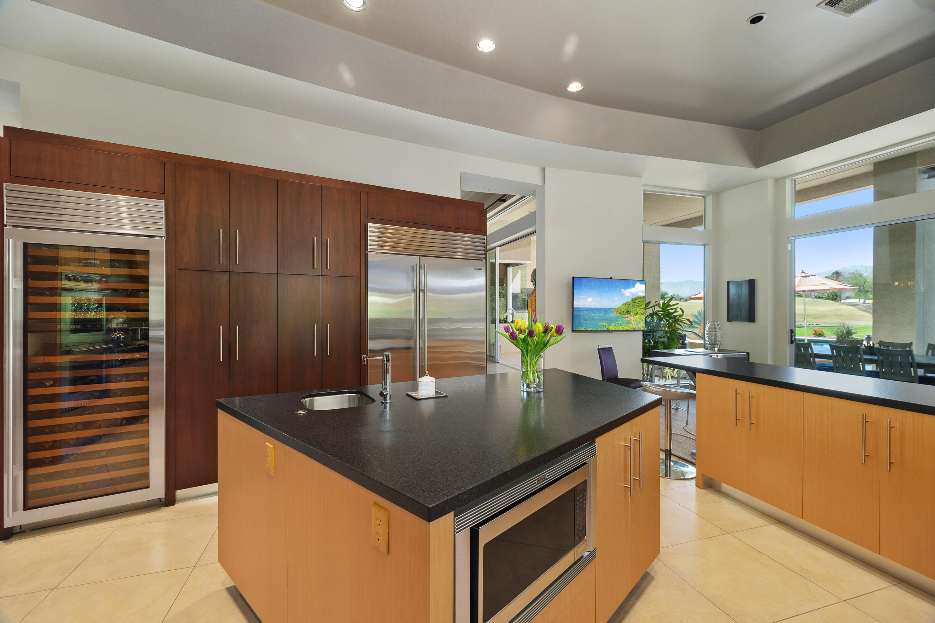 81 Royal St Georges Way Rancho Mirage, CA 92270 - Photo 30 of 59 a kitchen with stainless steel appliances granite countertop a sink a counter top space and living room view