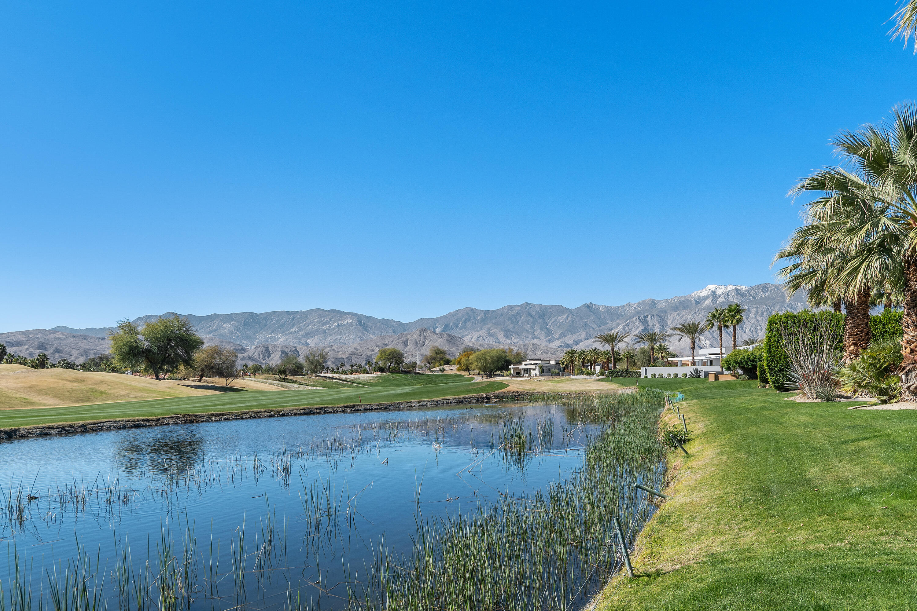 81 Royal St Georges Way Rancho Mirage, CA 92270 - Photo 50 of 59 a view of a lake with green field and trees