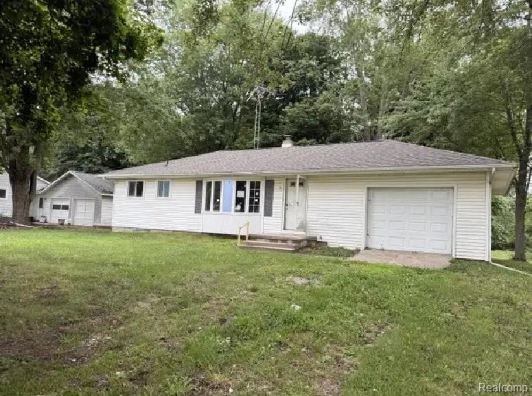 5407 Oak Grove Road Howell, MI 48855 - Photo 1 of 8 Ranch-style home featuring white vinyl siding, an attached two-car garage, and a gently sloped asphalt shingle roof