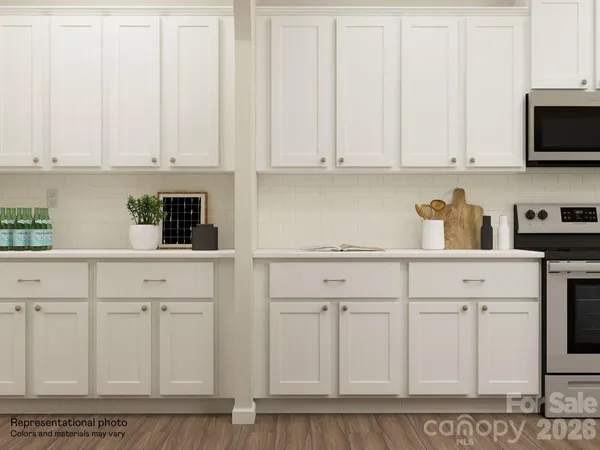 a living room with furniture wooden floor and kitchen view