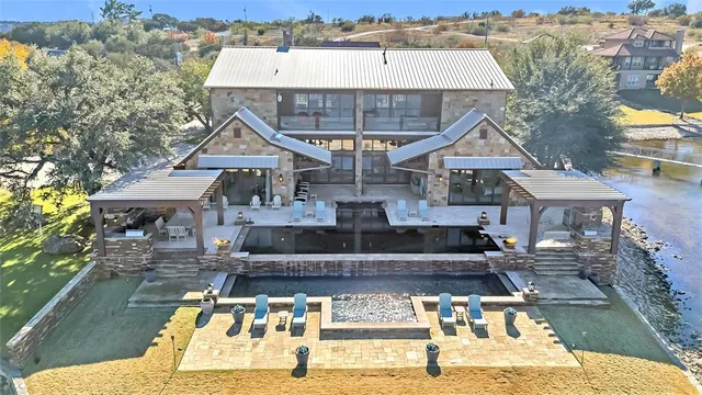 a view of a house with pool and chairs