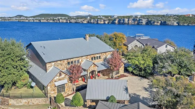 an aerial view of a house with a outdoor space and lake view