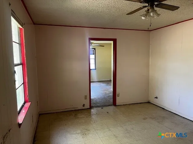 an empty room with a fan and a window