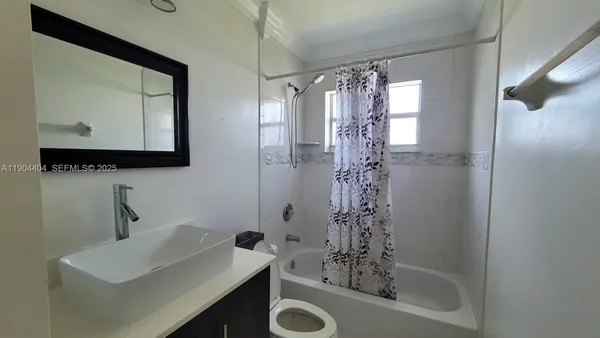 a bathroom with a sink a mirror a window and a shower