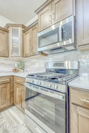 a kitchen with stainless steel appliances granite countertop a sink and cabinets with wooden floor