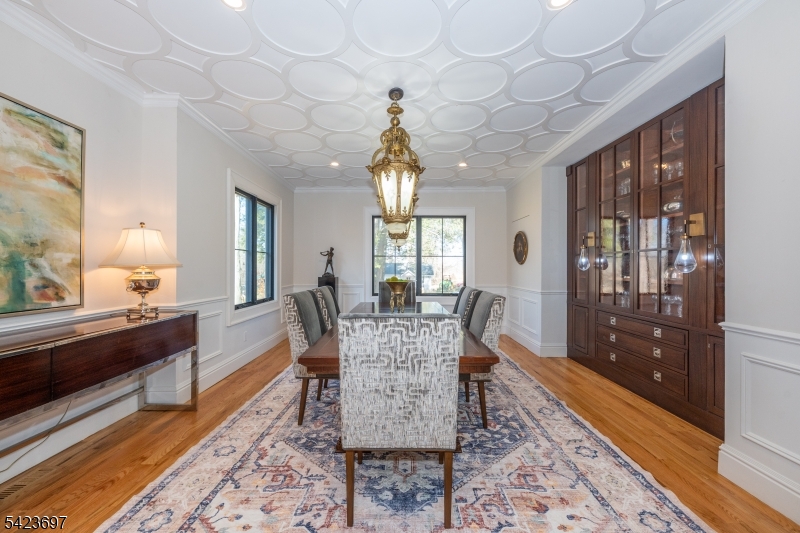45 Village Road New Vernon, NJ 07976 - Photo 17 of 49 a dining room with wooden floor a chandelier a wooden table and chairs