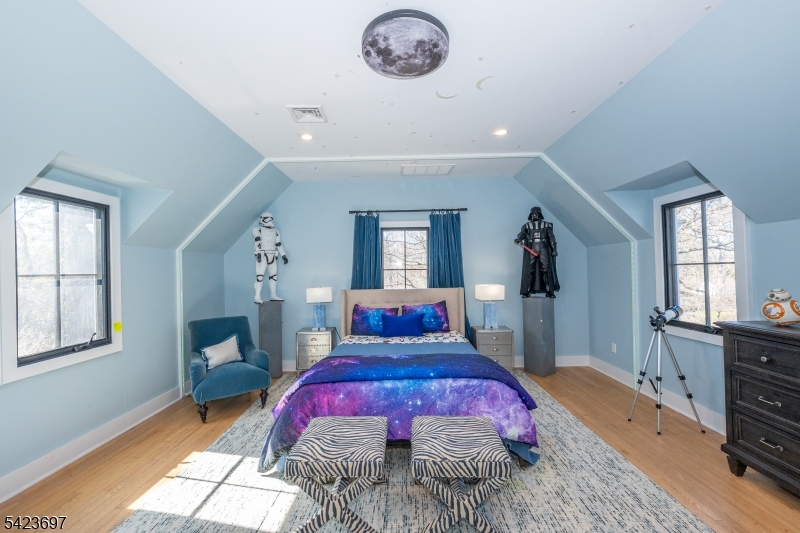 45 Village Road New Vernon, NJ 07976 - Photo 28 of 49 a bedroom with a bed and a chandelier