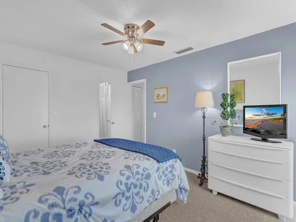 a bedroom with a bed a flat screen tv and wall painting