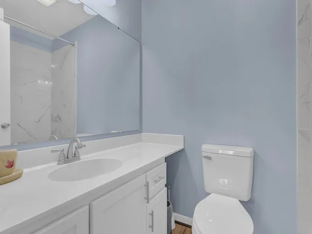 a bathroom with a toilet a sink and mirror