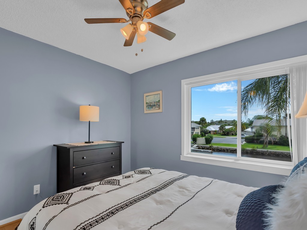 1860 Robalo Drive, Unit 203A Vero Beach, FL 32960 - Photo 18 of 36 a bedroom with a bed and a chandelier