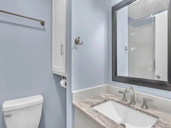 a bathroom with a granite countertop sink toilet and shower