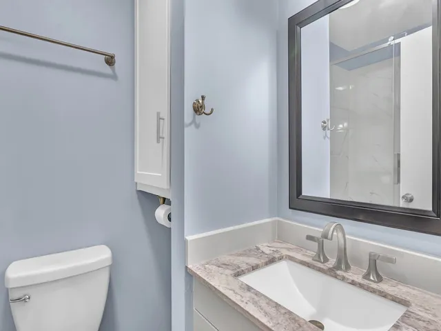 a bathroom with a granite countertop sink toilet and shower