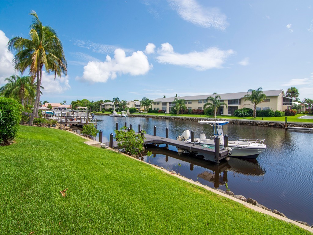 1860 Robalo Drive, Unit 203A Vero Beach, FL 32960 - Photo 20 of 36 a view of a lake with a table and chairs