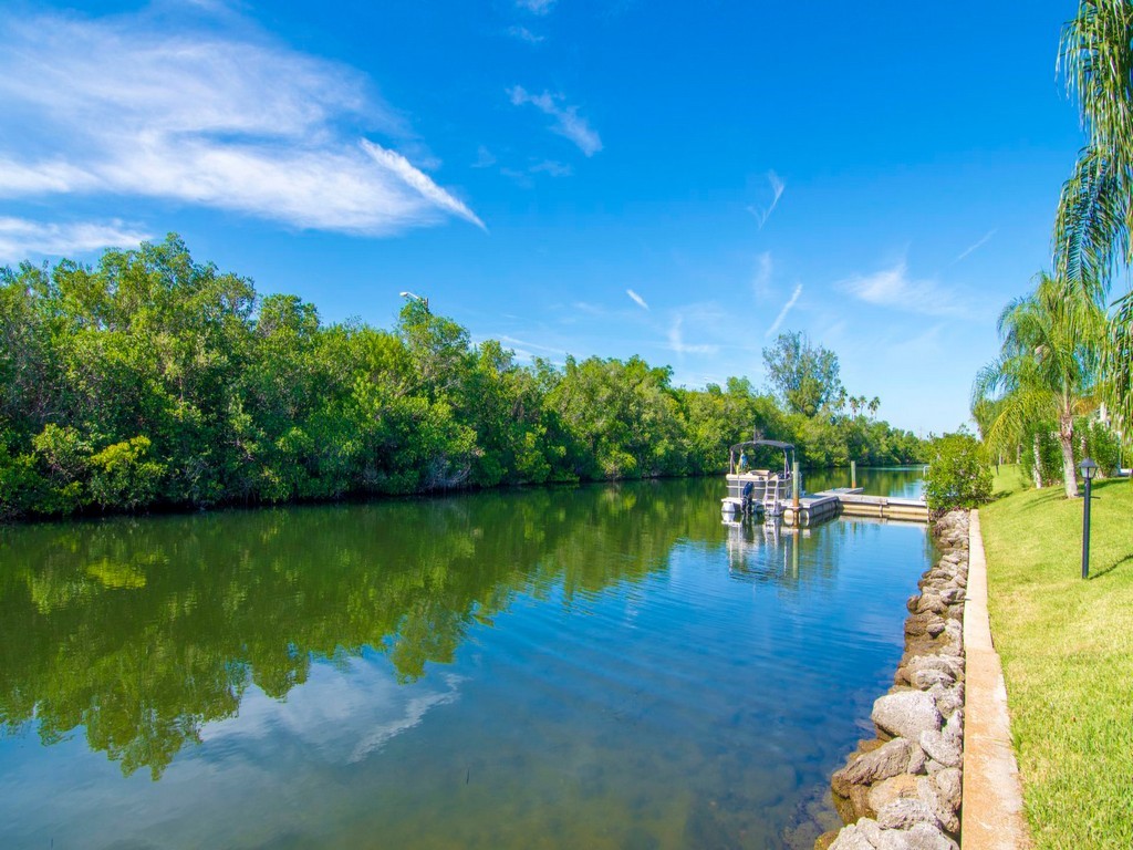 1860 Robalo Drive, Unit 203A Vero Beach, FL 32960 - Photo 24 of 36 a view of a lake with houses in the back