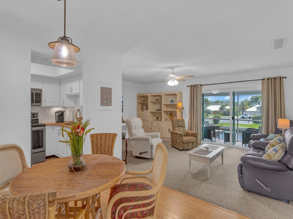 1860 Robalo Drive, Unit 203A Vero Beach, FL 32960 - Photo 3 of 36 a view of a dining room with furniture a chandelier and wooden floor