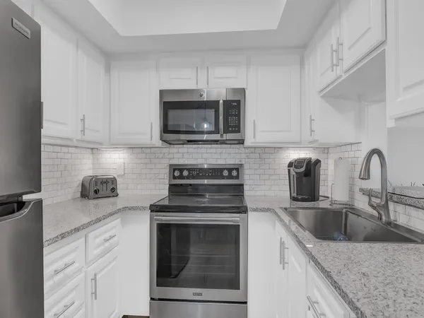 a kitchen with cabinets stainless steel appliances and a sink