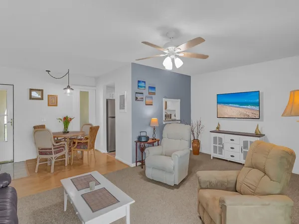 a living room with furniture a ceiling fan and a rug