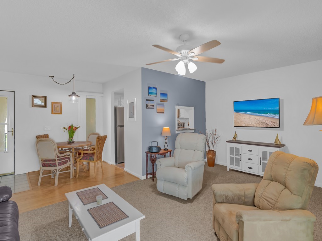1860 Robalo Drive, Unit 203A Vero Beach, FL 32960 - Photo 8 of 36 a living room with furniture a ceiling fan and a rug
