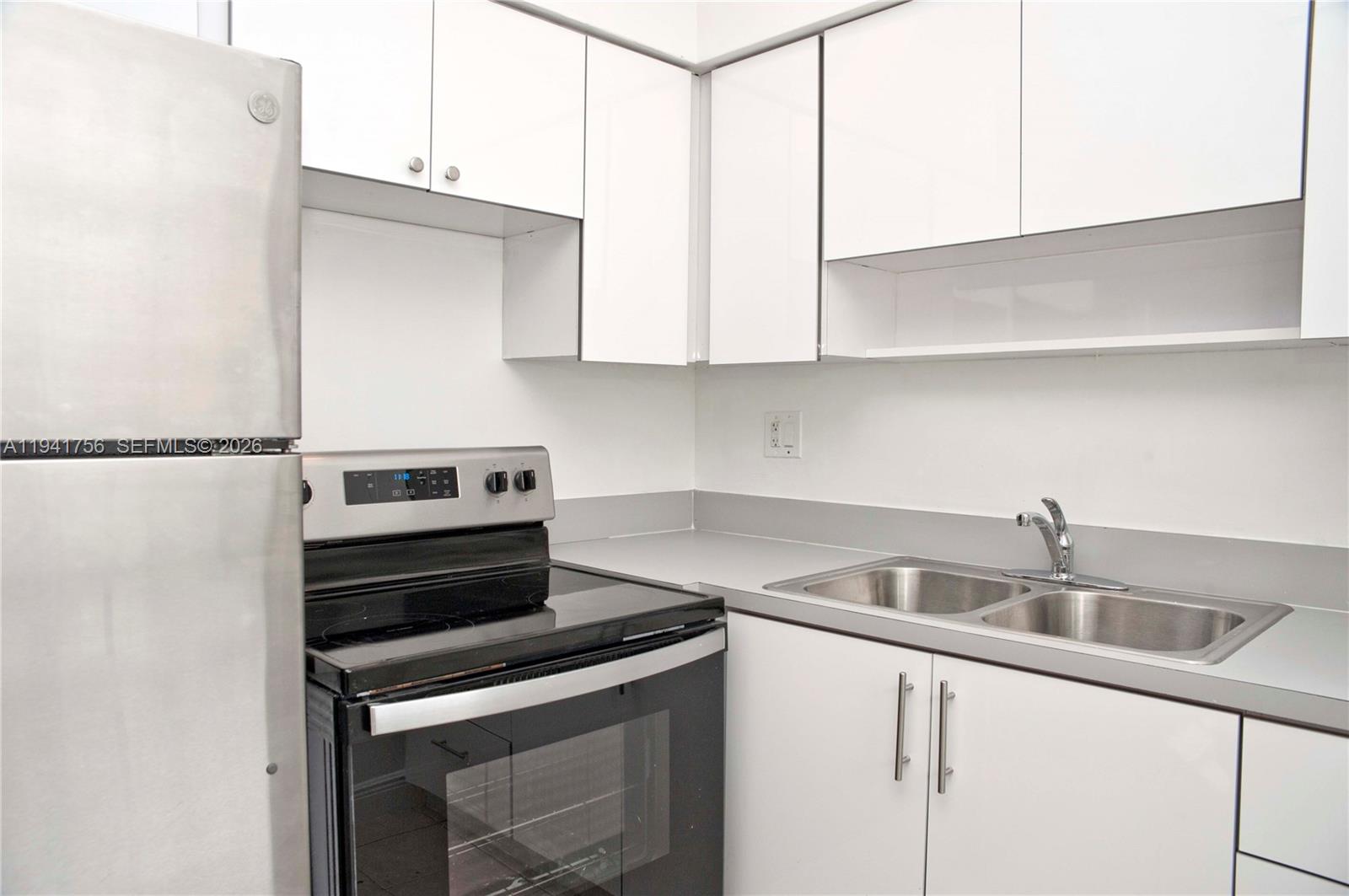 2206 Fillmore Street, Unit 3 Hollywood, FL 33020 - Photo 2 of 12 a kitchen with granite countertop a sink a stove and cabinets
