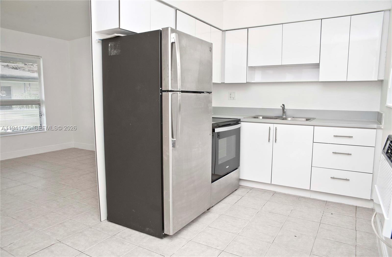 2206 Fillmore Street, Unit 3 Hollywood, FL 33020 - Photo 3 of 12 a kitchen with granite countertop white cabinets and refrigerator