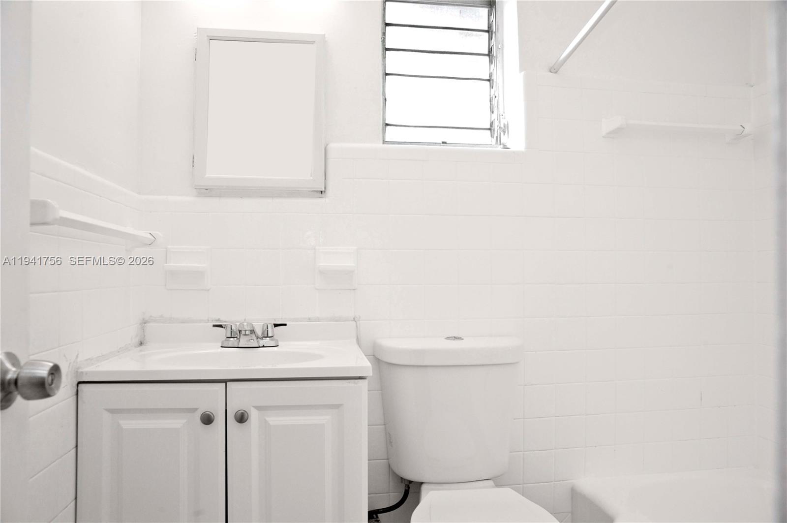 2206 Fillmore Street, Unit 3 Hollywood, FL 33020 - Photo 5 of 12 a bathroom with a sink a toilet and a mirror