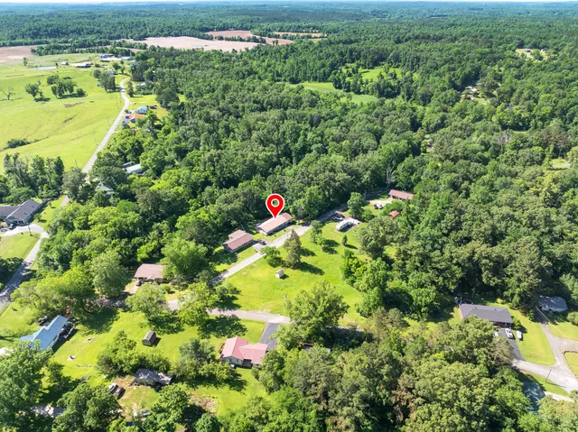 a living room with furniture a large window and wooden floor