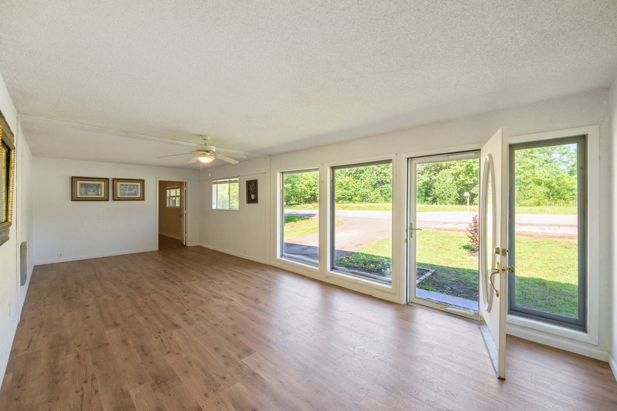 53 Elm Street Decaturville, TN 38329 - Photo 5 of 44 a view of an empty room with wooden floor and a window