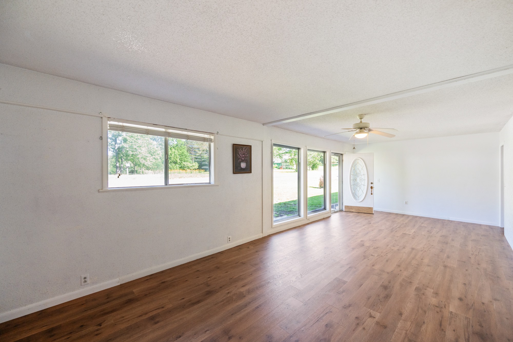 53 Elm Street Decaturville, TN 38329 - Photo 6 of 44 an empty room with wooden floor and windows