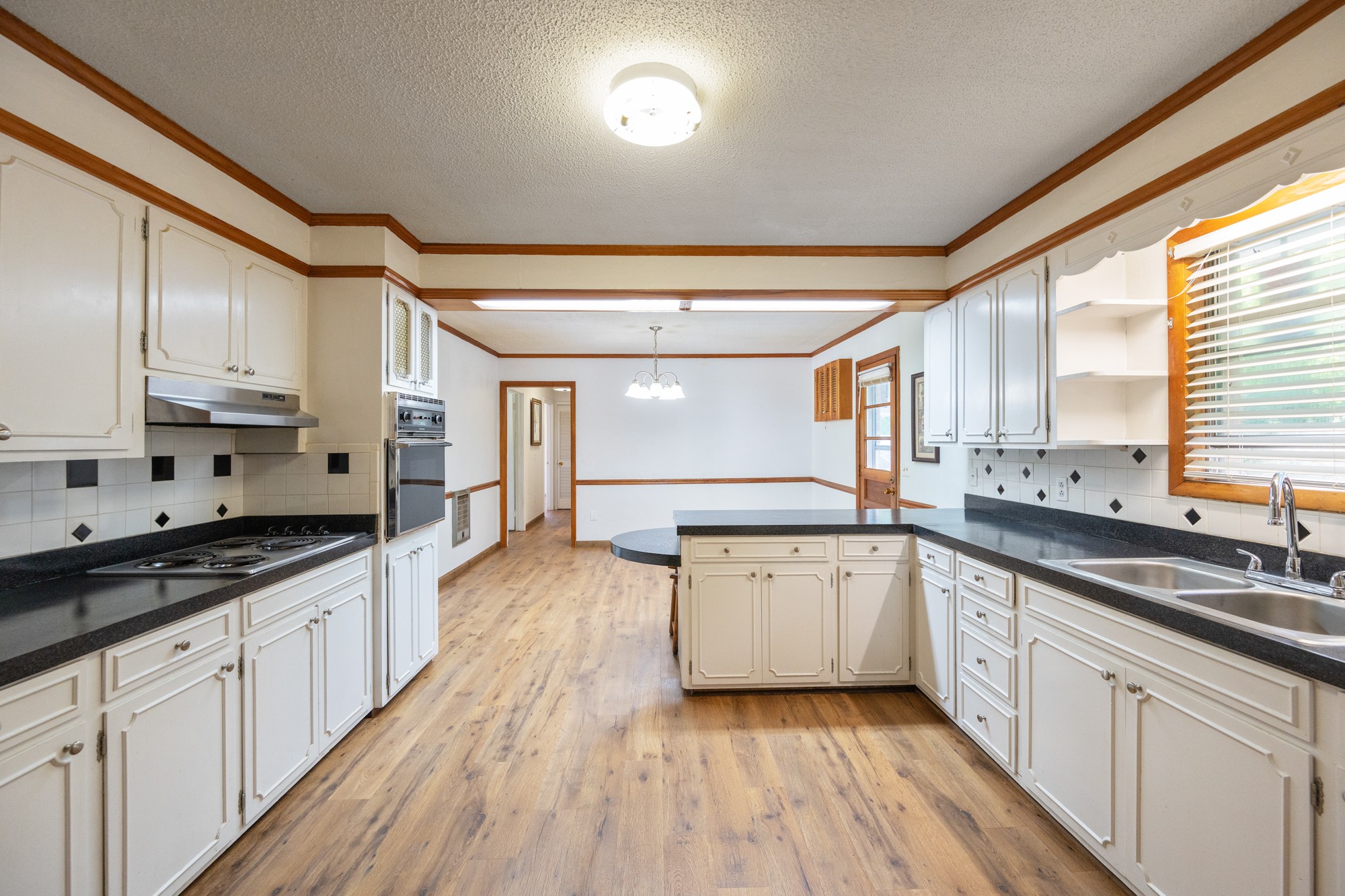 53 Elm Street Decaturville, TN 38329 - Photo 7 of 44 a large kitchen with stainless steel appliances granite countertop a lot of counter space and wooden floors