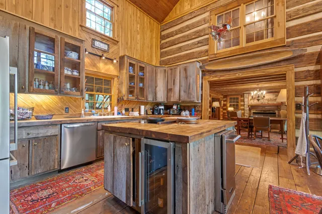 a living room with furniture a large window and wooden floor
