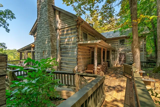 a view of backyard with table and chairs and a large tree