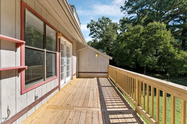 a view of balcony with wooden floor and fence