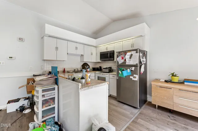 a kitchen with refrigerator and cabinets