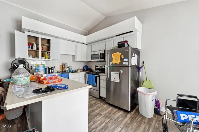 a kitchen with a sink appliances and wooden floor