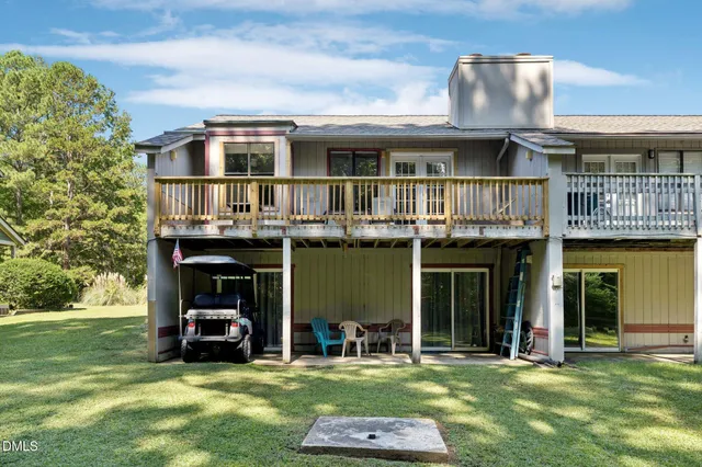 a view of a building with a big yard and large trees