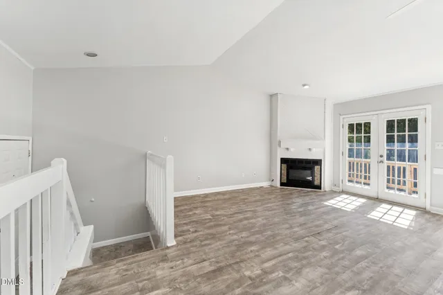 a view of an empty room with a fireplace and a window