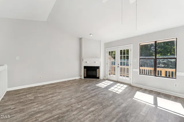 a view of a livingroom with wooden floor and a fireplace